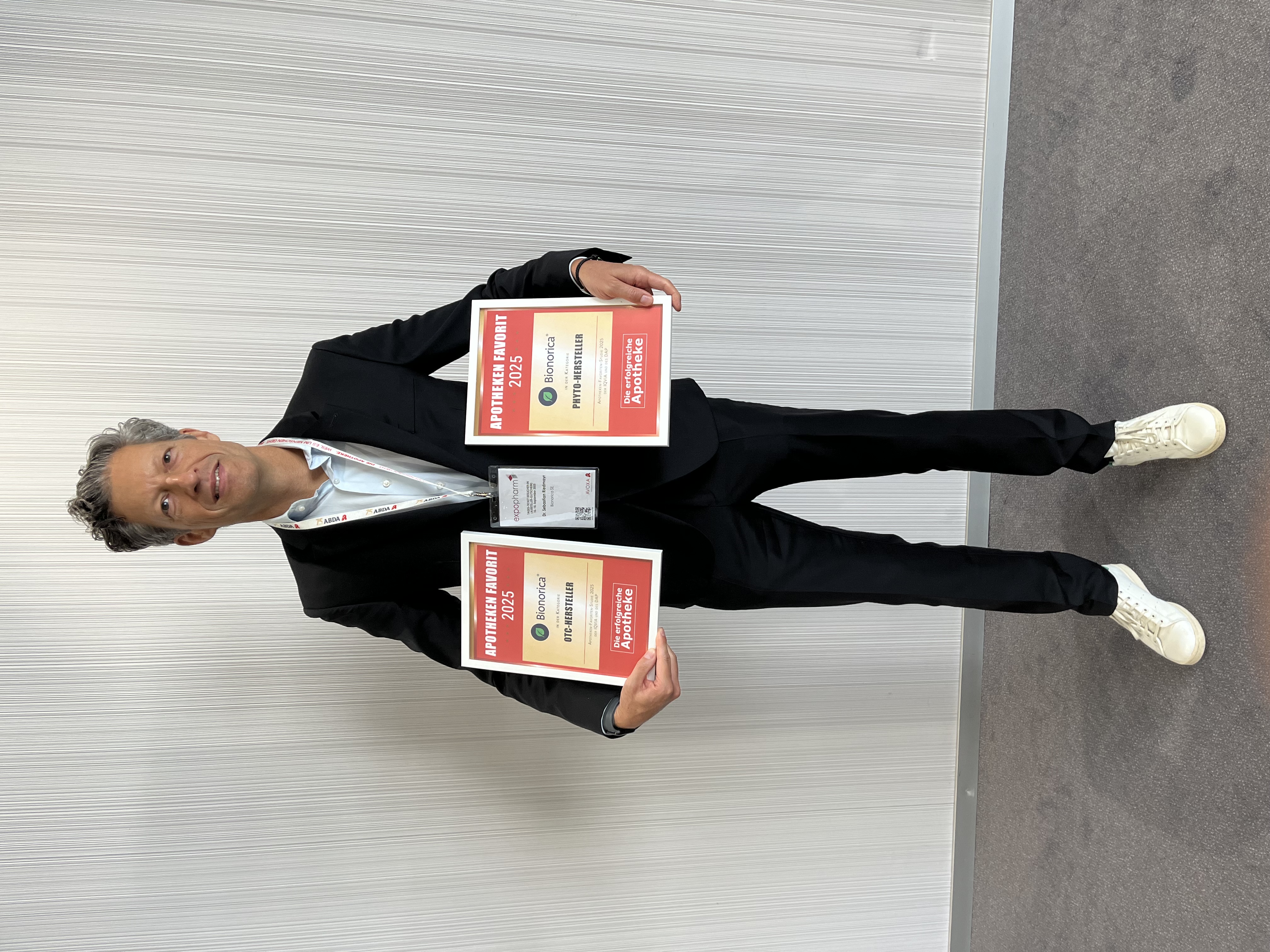 Dr. Riedmayr mit den beiden Auszeichnungen, die die Bionorica SE als "Apotheken Favorit 2025" auf der Expopharm in Düsseldorf erhalten hat