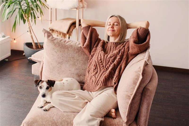 Frau mit einem Hund auf einer Couch