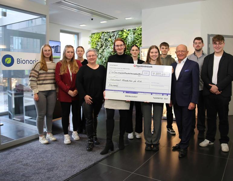 Symbolische Spendenscheckübergabe zwischen den Auszubildenden und der Natureheart Foundation for Kids